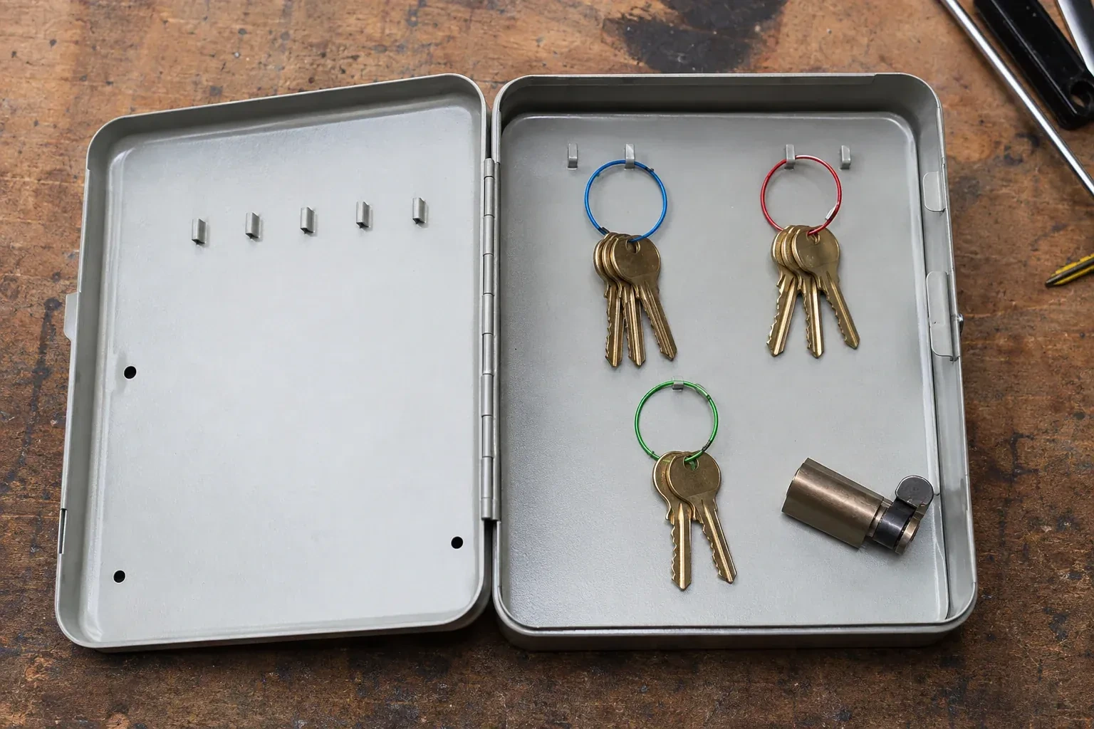 Three groups of keys on colored rings in an open metal key cabinet. — Master Key System Design, Hamilton